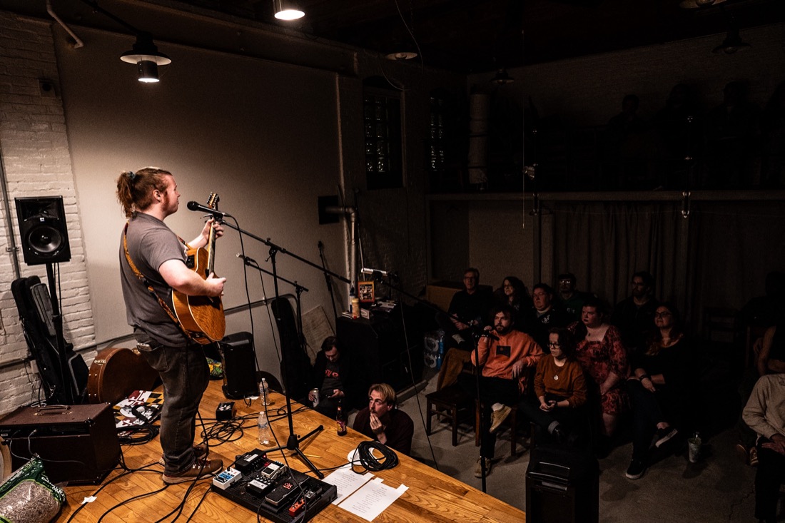 Braedan Coghlan playing solo acoustic to a full seated room